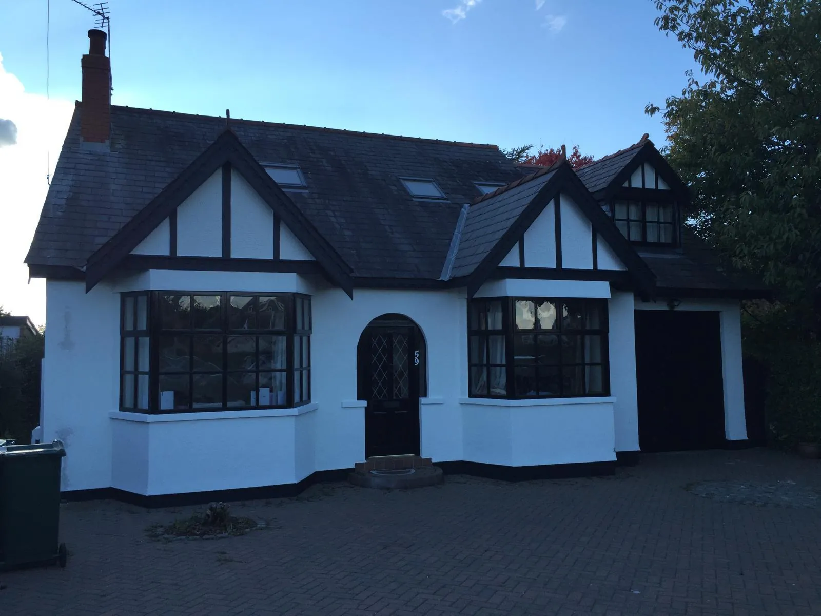 The same cottage after render coating, timber picked out in black