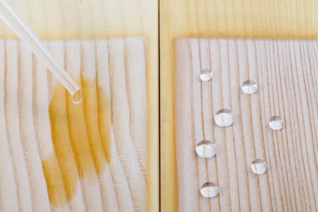 Water soaking into untreated timber and beading on treated timber